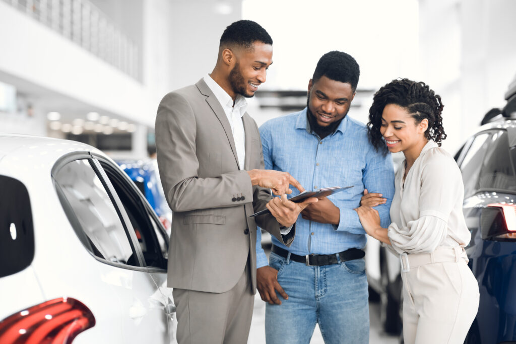 young couple talking with salesman about the best ways to finance buying a car