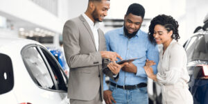 young couple talking with salesman about the best ways to finance buying a car