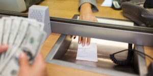 bank clerk giving receipt to customer after cashing a check