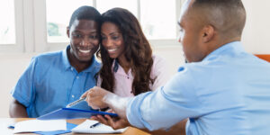 young couple refinancing their mortgage with an agent