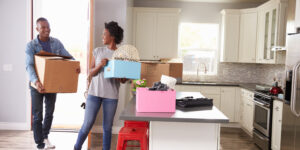 young couple carrying boxes into their new kitchen