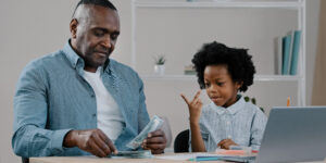 father and daughter showing how to teach financial concepts to your kids