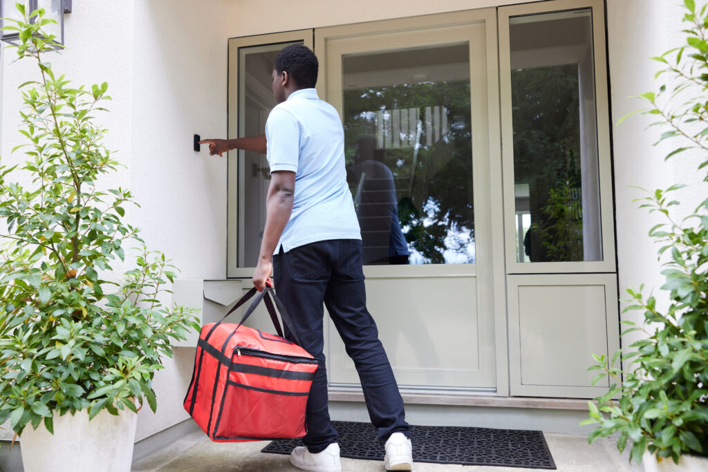 young man delivering food to a house