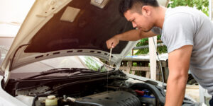 young man checking the oil to extend the lifespan of his car