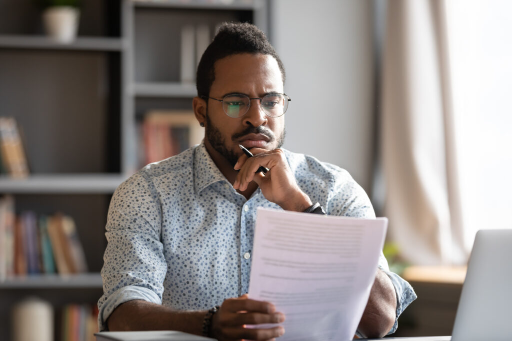 male student looking concerned as he spots a student loan scam red flag