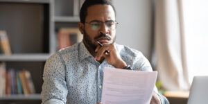 male student looking concerned as he spots a student loan scam red flag