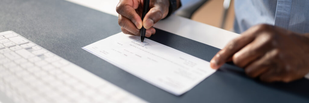 man writing a cashier's check