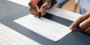 man writing a cashier's check